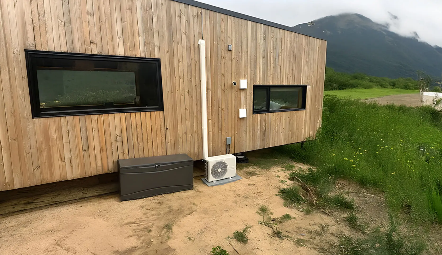 AC unit outside of a bungalow, a mountain range in the background.