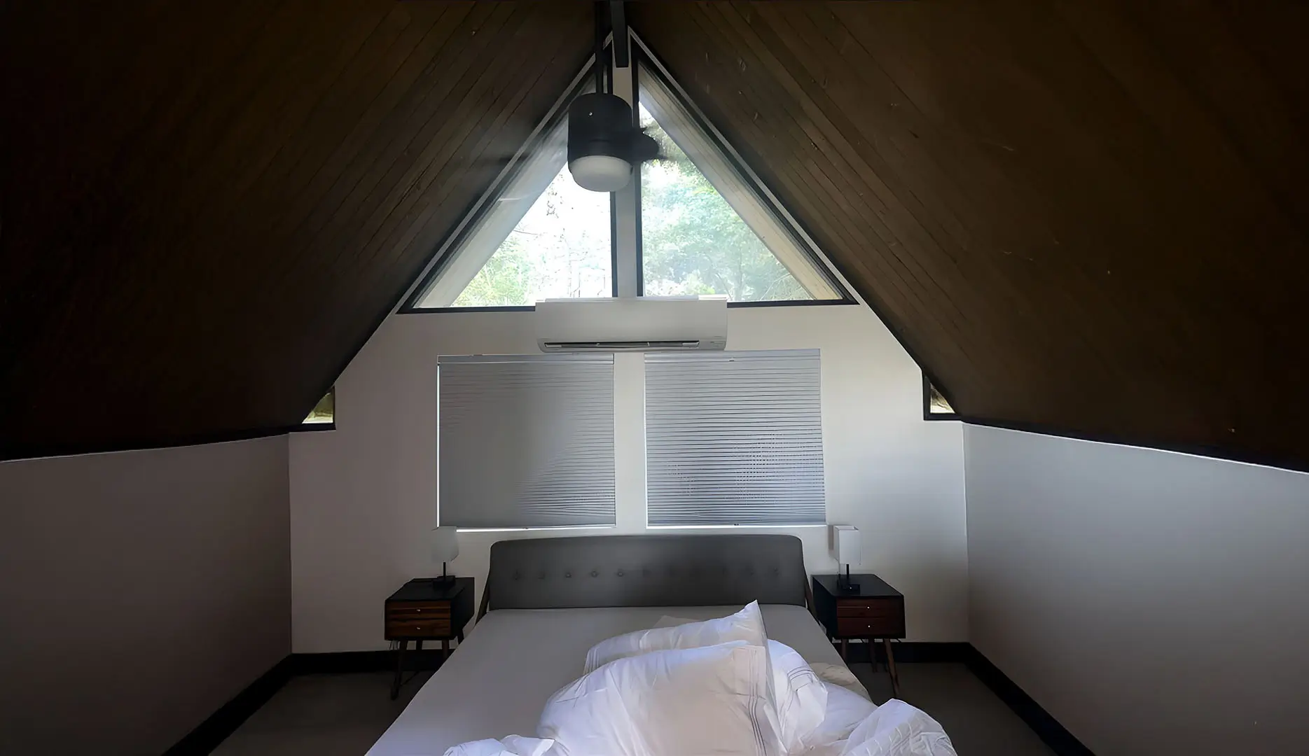 Ductless air conditioning system in a room with a ceiling made out of wood planks.