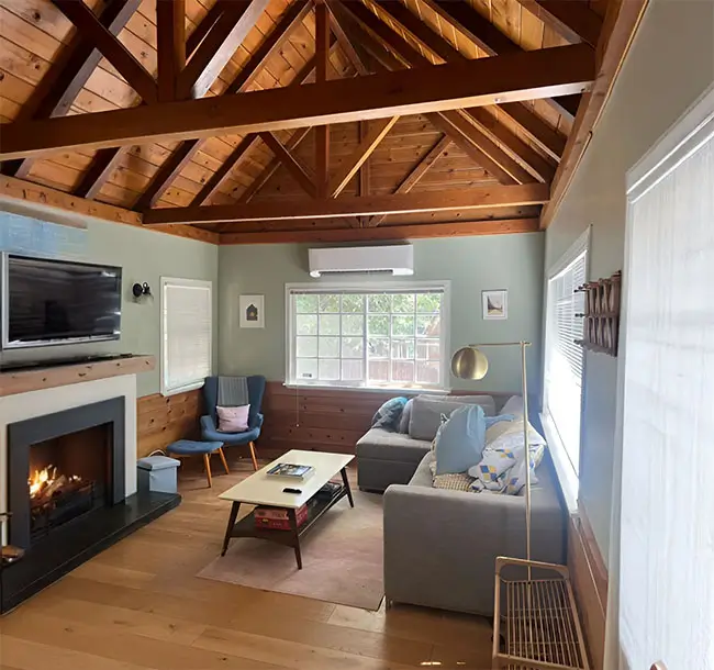 Ductless air conditioning system set up in a cabin. There is also a flat screen TV above the fireplace.