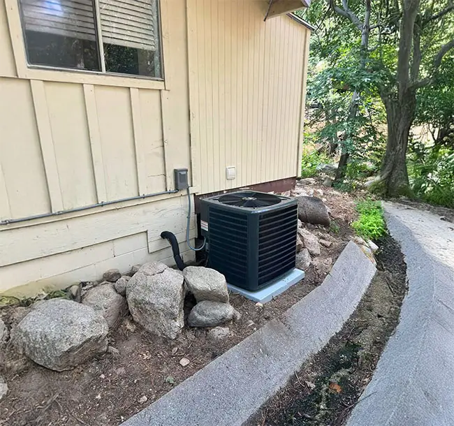 Single AC unit standing outside a home.