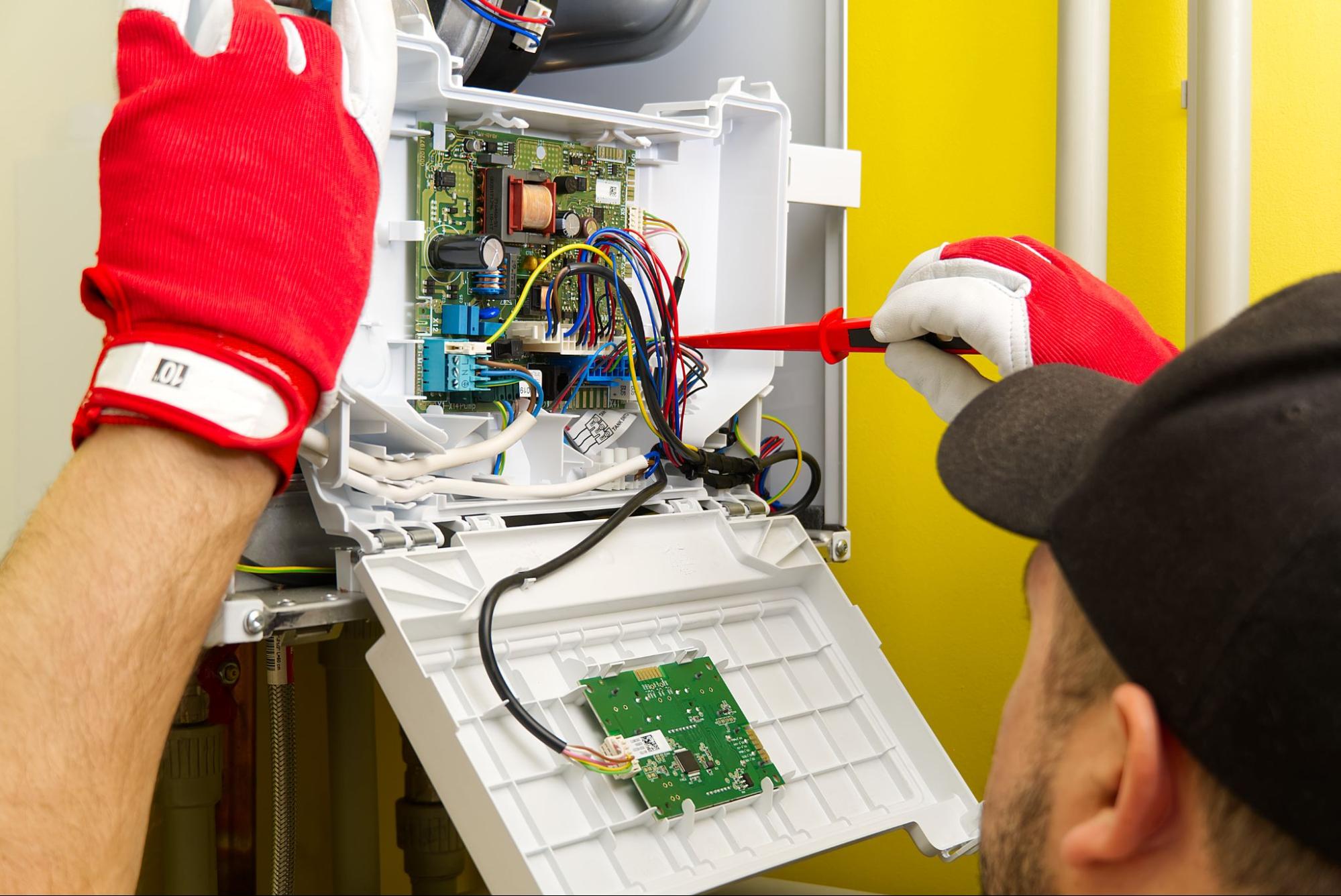 The electrician performs a detailed repair on the ground heater circuit board.