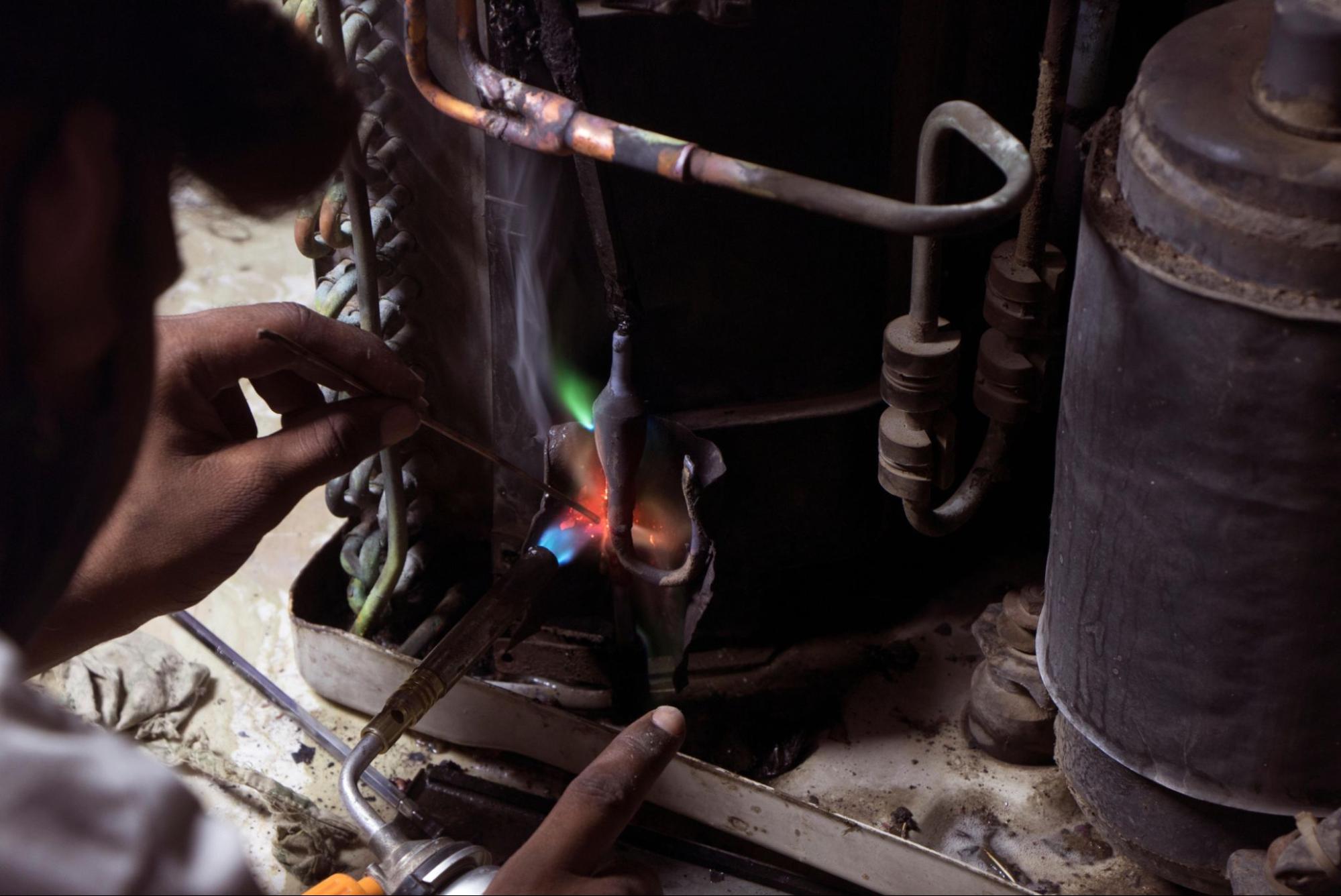Hands fixing internal parts of a home heating system.