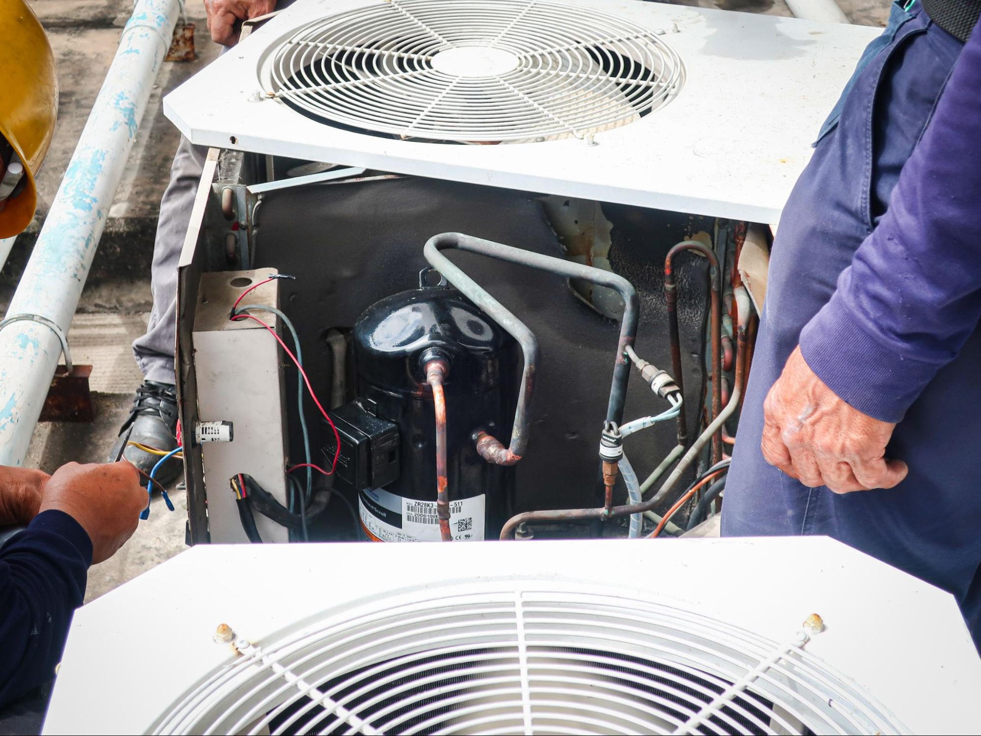 An air conditioning unit is taken apart for AC repair services.