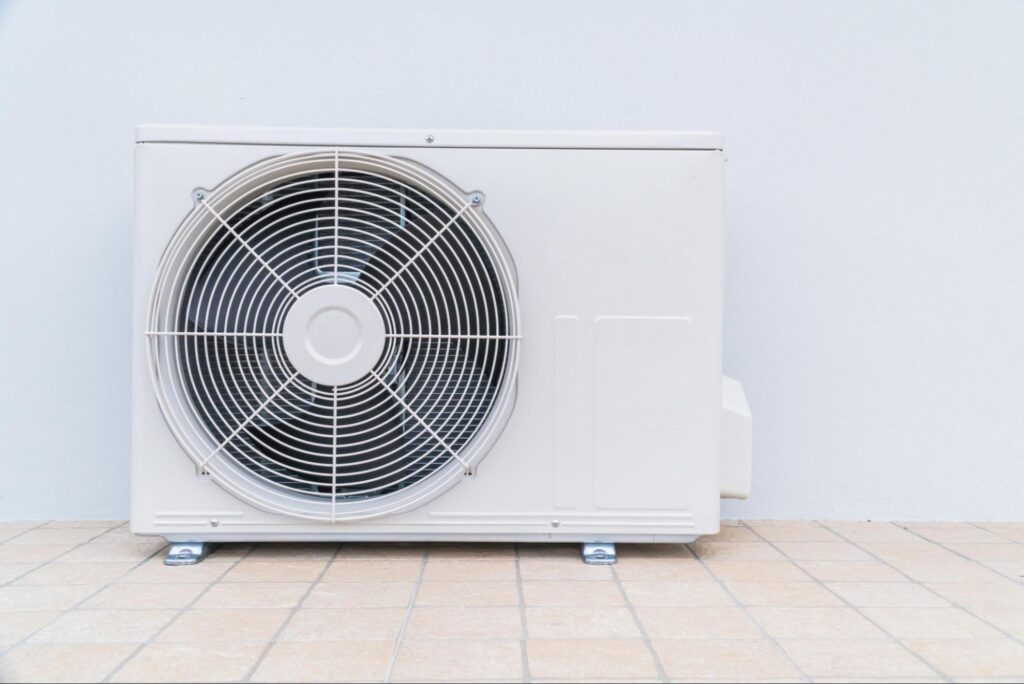 A mini split system sitting on the floor of a home’s interior.