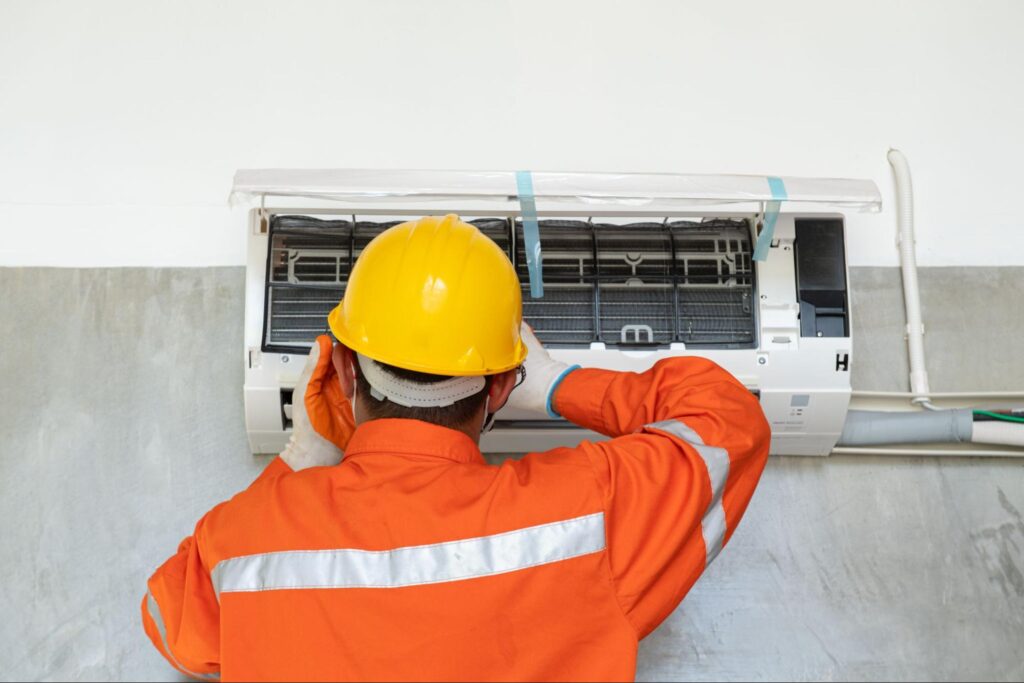 An HVAC professional services a ductless ac unit.