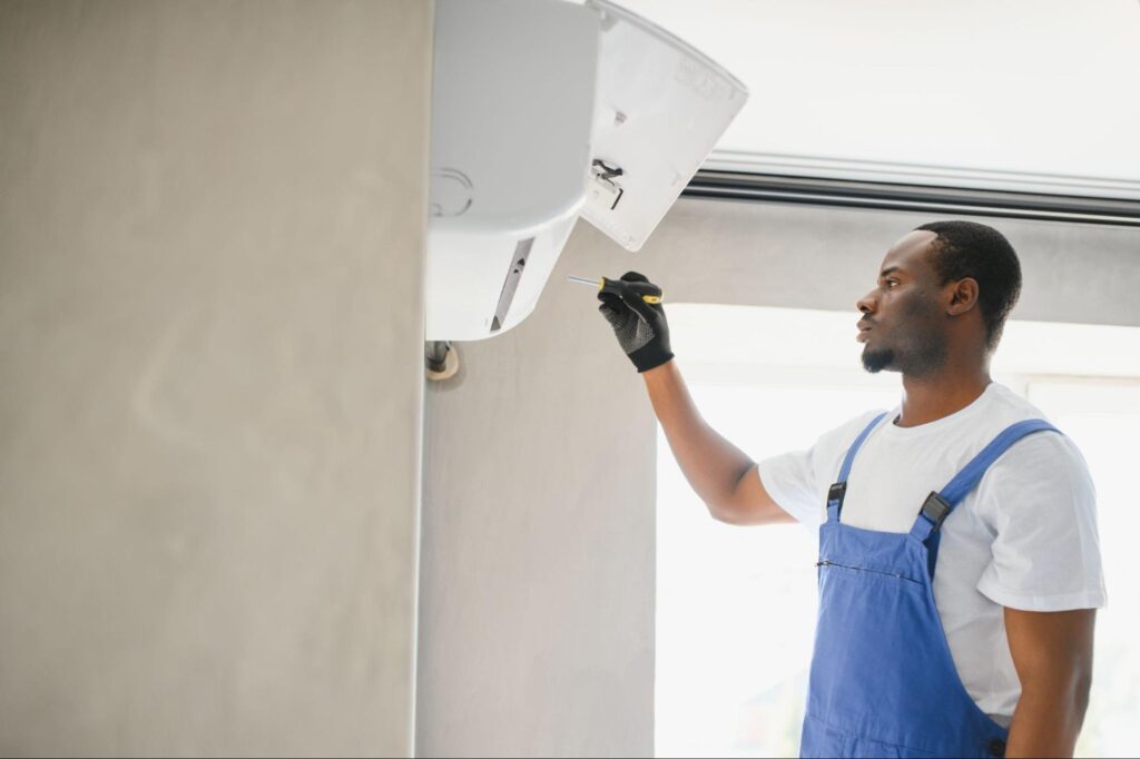 An African technician checking the performance of a freshly installed home AC system
