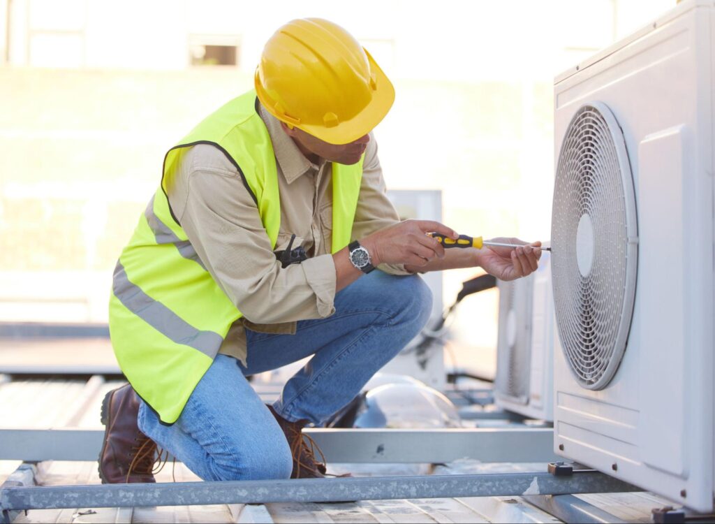 Air conditioning specialist working on a rooftop condenser fan as part of system installation