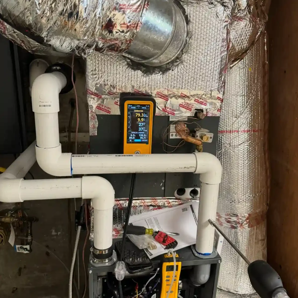 Sealed ductwork intertwined with tubes of a complex heating system.